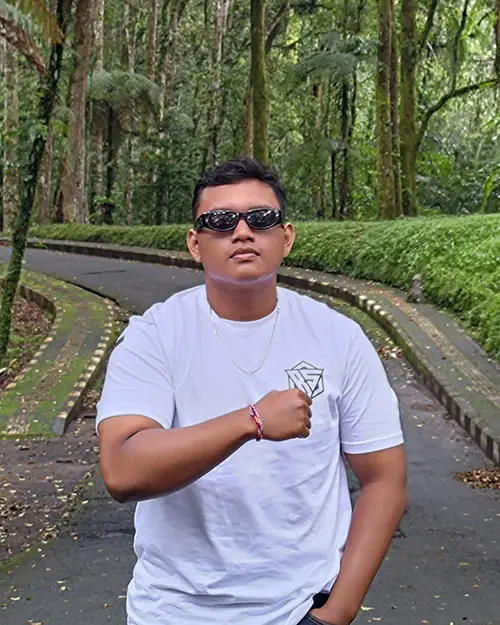 Jaya Anggara in a white T-shirt on a forest path