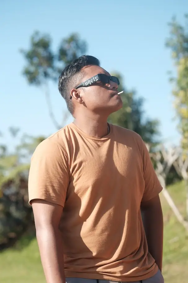 Jaya Anggara in an orange T-shirt and sunglasses outdoors
