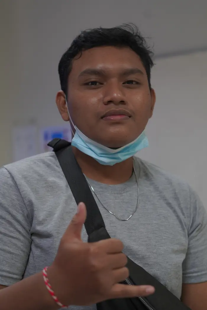 Jaya Anggara wearing a face mask and making a shaka sign